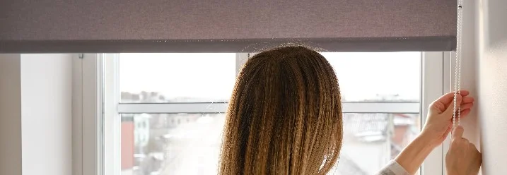 Person bedient ein Rollo mit einer Perlenkette.